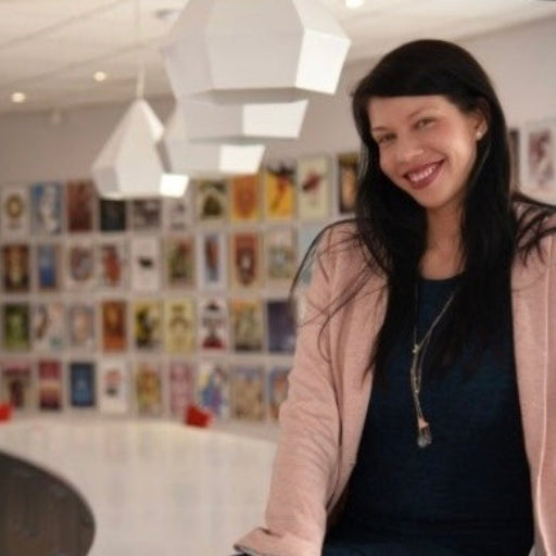 Woman standing in a room with a wall of small framed pictures